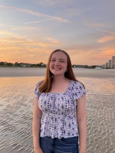 Molly Freeman smiling in front of ocean sunset